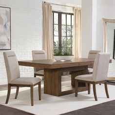 a dining room table and chairs in front of a large window with white brick walls