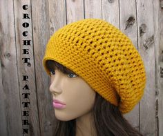 a mannequin head wearing a yellow knitted hat on top of a wooden surface