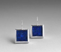 These colorful earrings are made with lapis lazuli and a combination of fine silver and sterling silver. Each earring has been bezel set with natural lapis lazuli in pretty, dark blue colors with occasional inclusions of silvery pyrite.  The silver has been surface brushed and burnished to Contemporary Drop Earrings For Gift, Modern Pendant Earrings As Gift, Contemporary Pierced Earrings For Gift, Contemporary Earrings As A Gift, Blue Fusion Earrings For Pierced Ears, Contemporary Blue Jewelry For Gifts, Blue Gemstone Pendant Earrings, Handmade Contemporary Drop Earrings, Contemporary Handmade Earrings For Formal Occasions