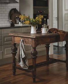 a wooden table with flowers on it in a kitchen