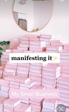 many pink boxes stacked on top of each other in front of a mirror with the words manfesting it