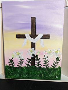 a painting of a cross with lilies in the grass and purple sky behind it