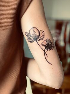 a woman's arm with a flower tattoo on the left side of her arm