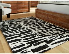 a large black and white rug in a bedroom