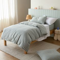 a bed with blue and white comforter in a bedroom