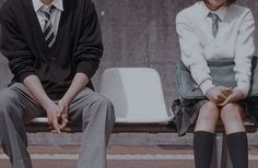 a man and woman sitting on a bench next to each other