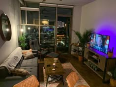 a living room filled with furniture and a flat screen tv sitting on top of a wooden table