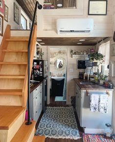 the interior of a tiny home with stairs leading up to the kitchen and living room