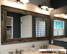 a bathroom with two sinks, mirrors and lights on the wall above them is shown