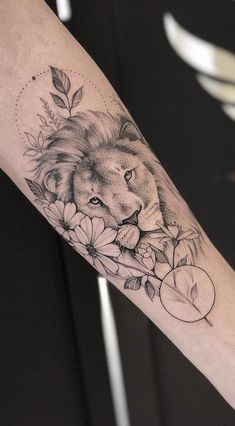 a lion and flowers tattoo on the arm