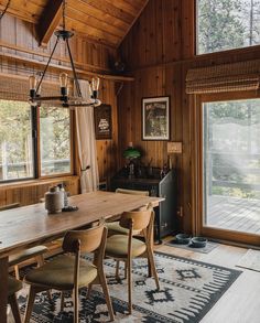 a wooden dining room table and chairs in front of a sliding glass door that leads to a deck