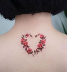 a woman's back neck with flowers in the shape of a heart on it