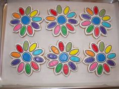 four decorated cookies on a cookie sheet in the shape of flowers