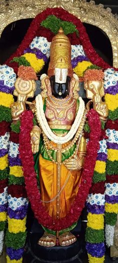 the statue is decorated with flowers and garlands