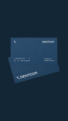 two blue business cards with the word denttoor printed on them, against a dark background