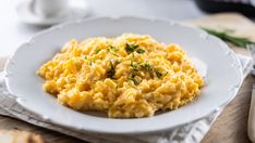 scrambled eggs with chives on a white plate