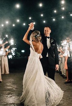 a bride and groom holding sparklers in their hands as they walk down the aisle