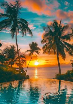 the sun is setting behind some palm trees near an empty swimming pool with blue water