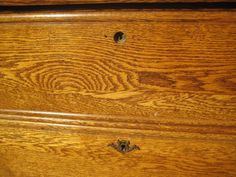 an old wooden dresser with two knobs on the top and one drawer open to show woodgrain