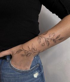 a woman with a tattoo on her arm holding onto the back of her left hand