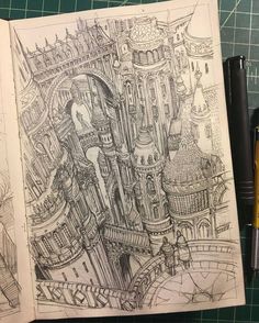 an open book with a drawing of a castle on the cover and some pens next to it