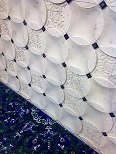 an artisticly designed wall with blue and white tiles