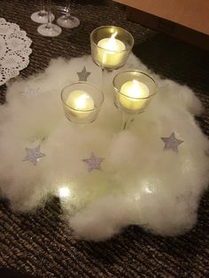 three candles are lit on top of some fluffy material