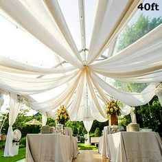 an outdoor wedding venue with white draping and tables