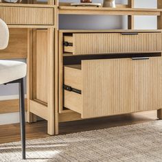 a desk with drawers and a chair in front of it on a carpeted floor