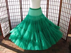 "This listing is for a custom order for the emerald green single layer petticoat in the photos. It will be made of soft nylon organdy with bridal satin covered waistband. The pictured petticoat was designed for a 40\" (101,5cm) waist and is 36\" (91,5cm) long. It is displayed on a dress form with a 22\" (56cm) waist -- the petticoat is pinned in the back so it doesn't slide off ;) Please feel free to ask me any questions or request other colors :) WAIST: Please select your waist from the listed Fitted Green Petticoat For Spring, Elegant Stretch Petticoat With Attached Cancan, Fitted Spring Organza Petticoat, Spring Fitted Organza Petticoat, Fitted Organza Petticoat For Spring, Dress Form, Kelly Green, Petticoat, Emerald Green