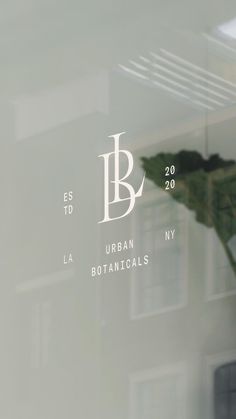 the logo for urban botanicals is seen through a window