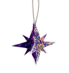 a purple star ornament hanging from a string on a white background with colorful sprinkles