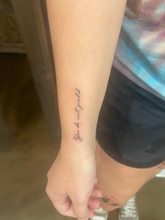 a woman with a tattoo on her arm and the word love is written in cursive writing