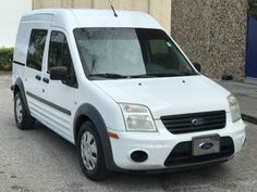 a white van parked in front of a building