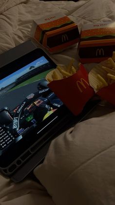 a tablet with french fries and mcdonald's on it is sitting on a bed