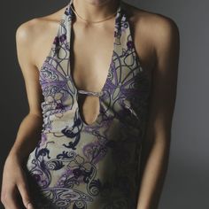 a woman wearing a halter top with purple flowers on it