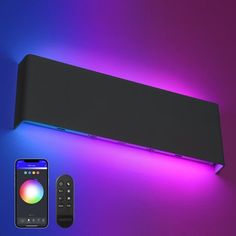 an electronic device is next to a remote control on a purple and blue background with lights