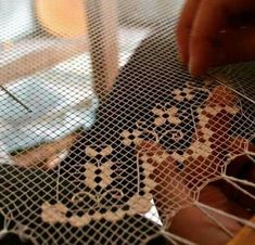 a person is working on some type of art work with wire and wood pieces in front of them