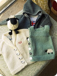 a knitted sweater with sheeps on it and a stuffed animal in the back