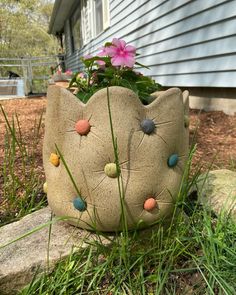 a cat planter sitting in the grass next to a house