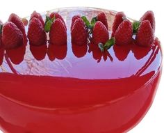 a red bowl filled with lots of ripe strawberries