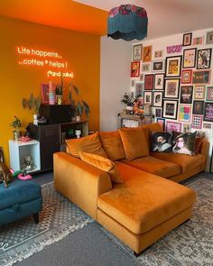 a living room with orange couches and pictures on the wall