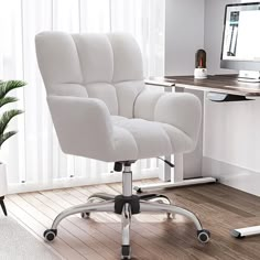 a white office chair sitting in front of a computer monitor