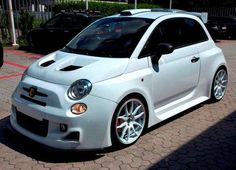 a small white car parked in a parking lot