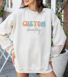 Wrap yourself in school spirit with our adorable custom crewneck, proudly displaying the name of your cherished elementary school. This sweatshirt not only showcases your school pride but also adds a touch of cuteness with a charming design. Ideal for dual language educators seeking a thoughtful and unique gift, this custom crewneck is perfect for showcasing your dedication to your school community. 📚 Ideal for dual language educators and teachers seeking personalized and meaningful gifts. 👕 P Oversized Letter Print Sweatshirt For School Spirit, Oversized Sweatshirt With Letter Print For School Spirit, Oversized Cotton School Spirit Sweatshirt, Personalized Casual Tops For Teacher Appreciation, Oversized Letter Print Sweatshirt For School, Personalized Crew Neck Sweatshirt In Relaxed Fit, Casual Customizable Sweatshirt For Fall, Oversized Cotton Sweatshirt For School Spirit, Personalized Relaxed Fit Crew Neck Sweatshirt