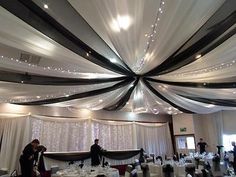 a banquet room with white and black drapes on the ceiling