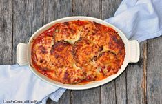 a casserole dish with cheese and tomato sauce on a wooden table, ready to be eaten