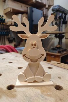 a wooden sculpture of a reindeer sitting on top of a table