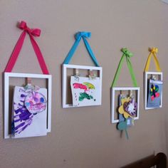 some pictures are hanging on the wall with colorful ribbons around them and attached to small frames