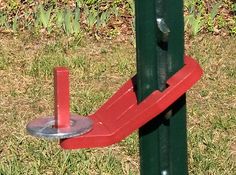 a close up of a red and green pole with a metal holder on it's side